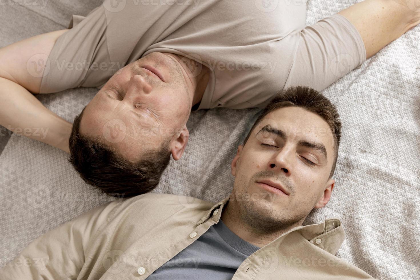 Happy gay couple with casual clothes spending time together at home. Two caucasian men relaxing. Homosexual relationships and alternative love. Cosy interior. photo