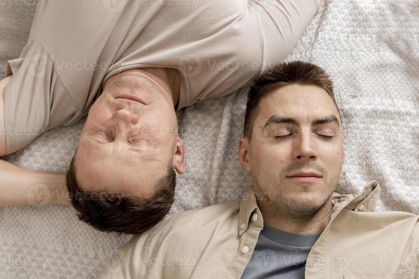 Happy gay couple with casual clothes spending time together at home. Two caucasian men relaxing. Homosexual relationships and alternative love. Cosy interior. photo