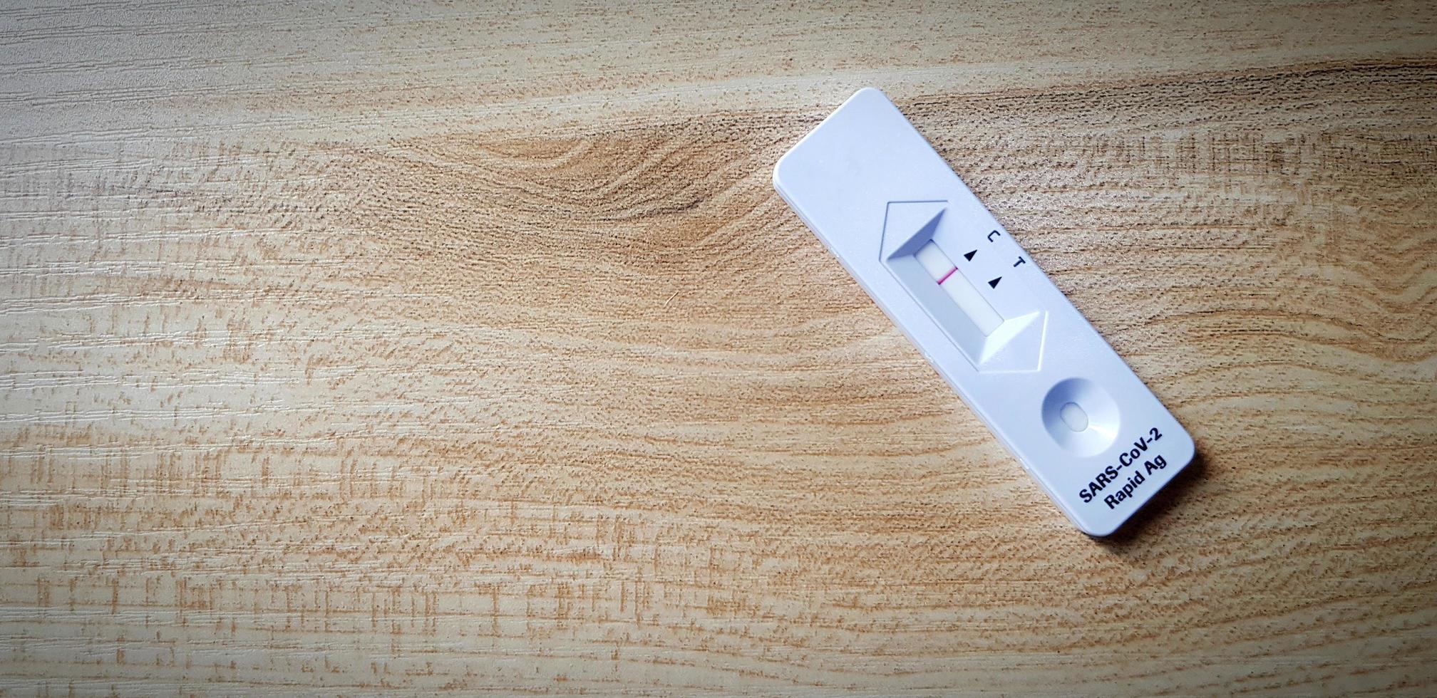 Covid antigen test kit on wooden table with copy space for people testing infected with virus by self before go to see doctor at hospital. Healthcare Tool for checking health on wood background. photo