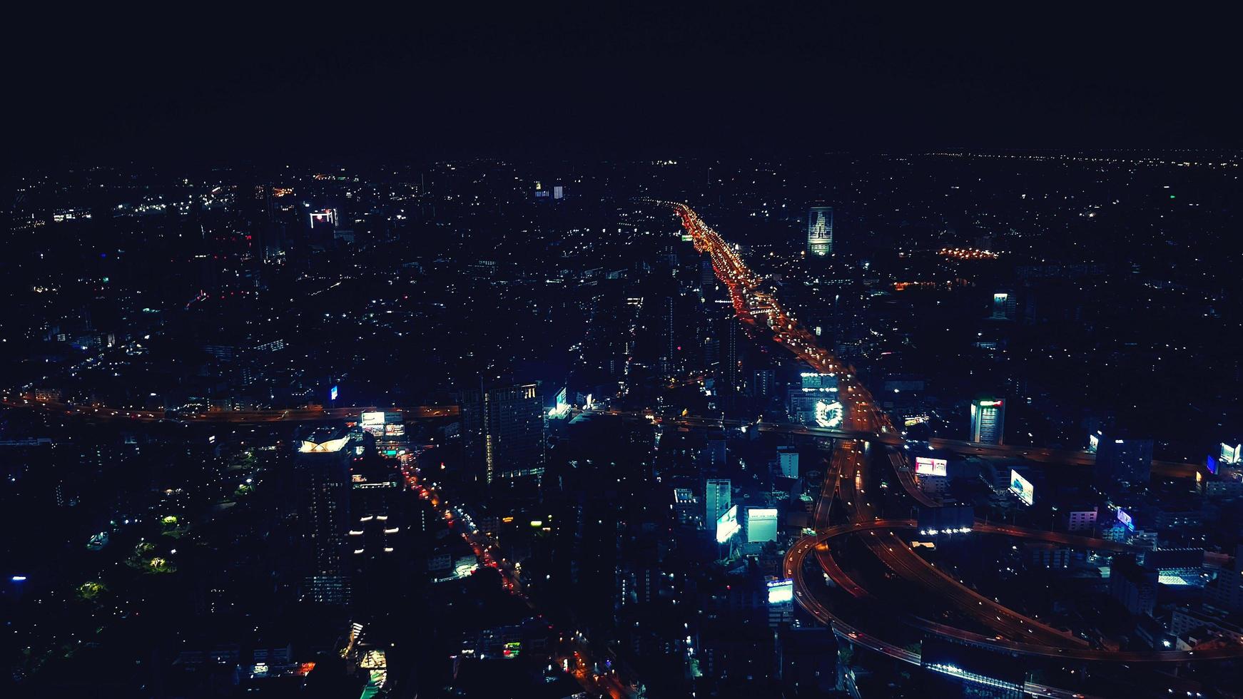 Aerial view of Bangkok city, Thailand at night. Landscape view of town with colorful light, street or road, transportation and highway in blue vintage tone. Beautiful life in Asian country concept photo