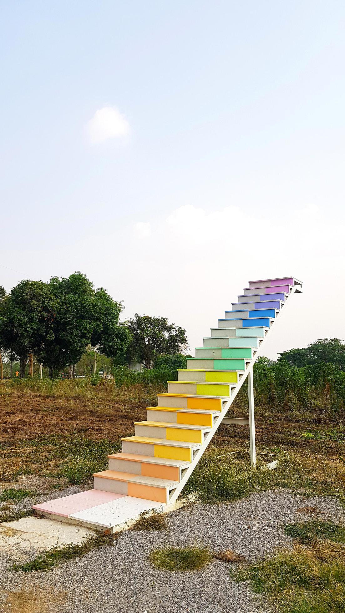 Rainbow or colorful stairs way or step at park with grass field, green