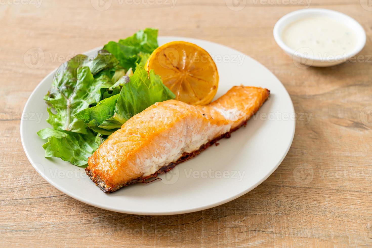 filete de salmón frito con limón y vegetales foto