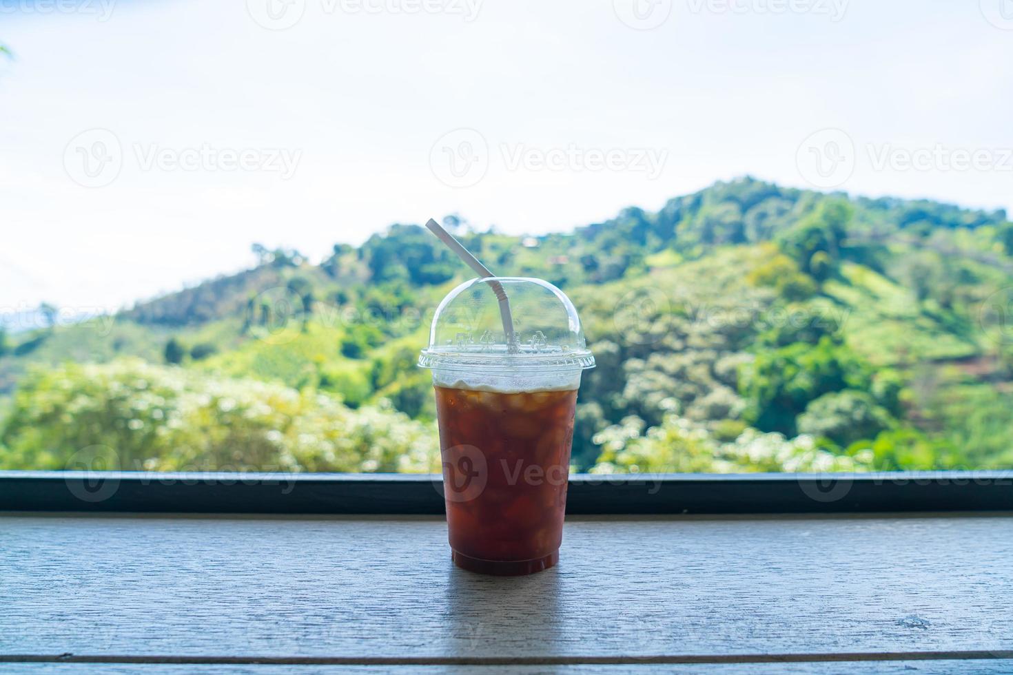 black coffee on wood bar with mountain hill background photo