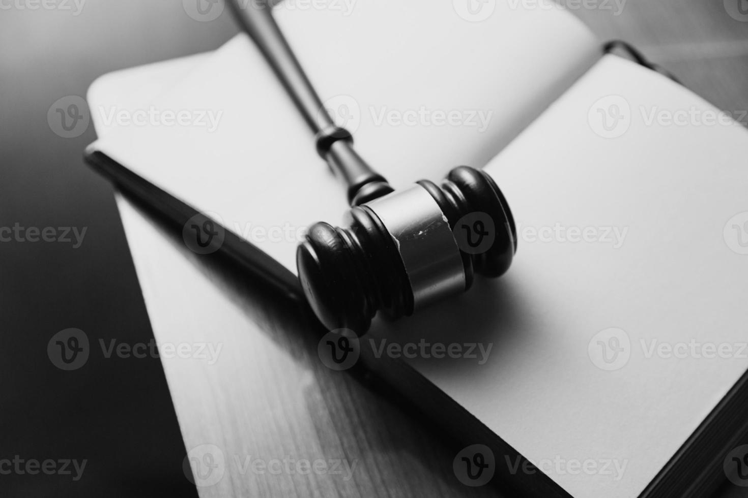 Justice and law concept.Male judge in a courtroom with the gavel, working with, computer and docking keyboard, eyeglasses, on table in morning light photo