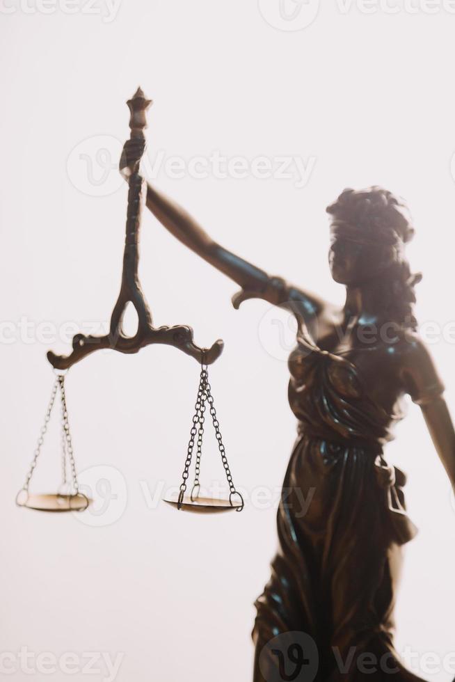 Justice and law concept.Male judge in a courtroom with the gavel, working with, computer and docking keyboard, eyeglasses, on table in morning light photo