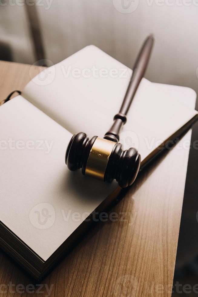 Justice and law concept.Male judge in a courtroom with the gavel, working with, computer and docking keyboard, eyeglasses, on table in morning light photo