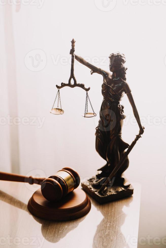 Justice and law concept.Male judge in a courtroom with the gavel, working with, computer and docking keyboard, eyeglasses, on table in morning light photo