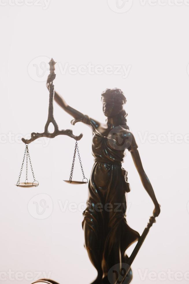 Justice and law concept.Male judge in a courtroom with the gavel, working with, computer and docking keyboard, eyeglasses, on table in morning light photo