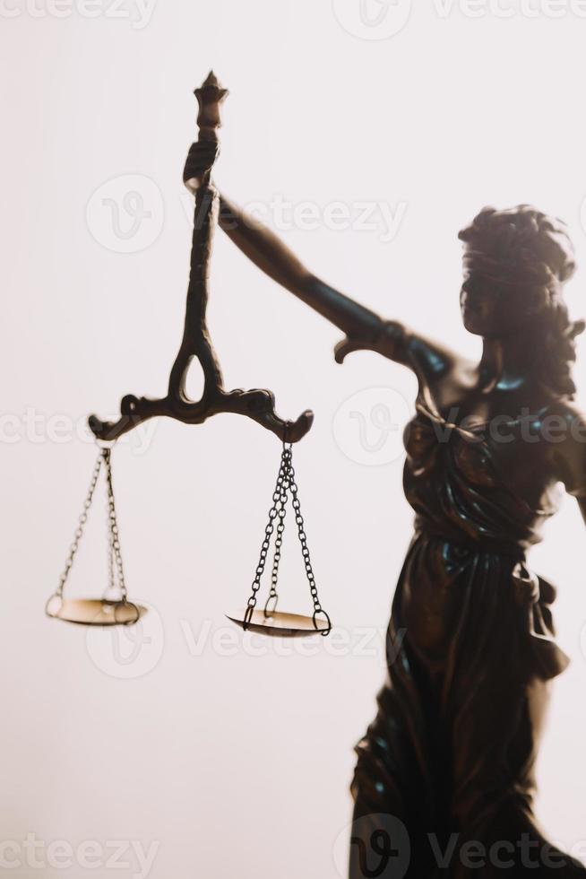 Justice and law concept.Male judge in a courtroom with the gavel, working with, computer and docking keyboard, eyeglasses, on table in morning light photo