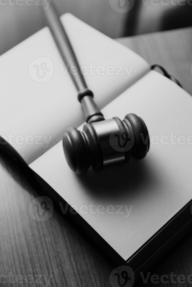 Justice and law concept.Male judge in a courtroom with the gavel, working with, computer and docking keyboard, eyeglasses, on table in morning light photo