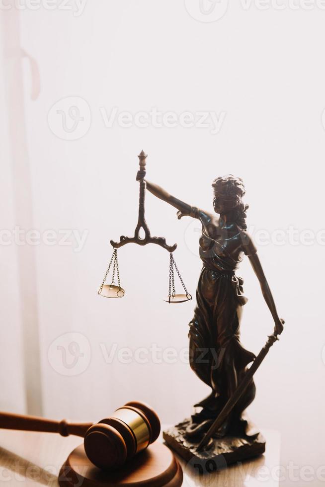 Justice and law concept.Male judge in a courtroom with the gavel, working with, computer and docking keyboard, eyeglasses, on table in morning light photo