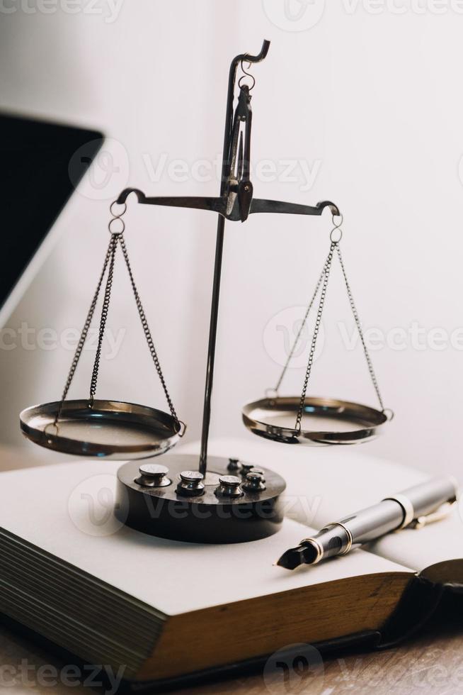 Justice and law concept.Male judge in a courtroom with the gavel, working with, computer and docking keyboard, eyeglasses, on table in morning light photo