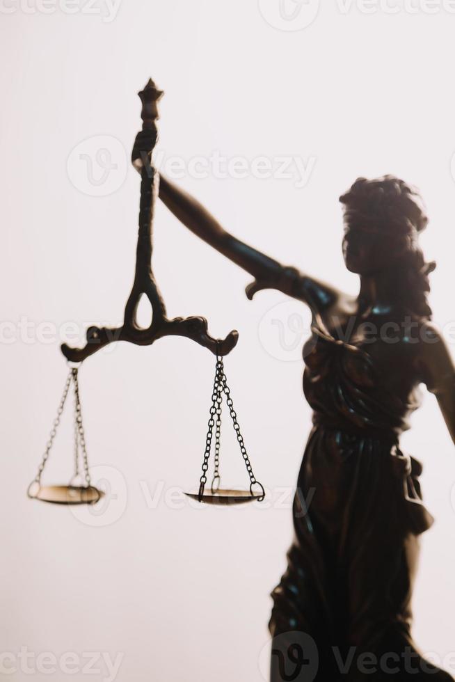 Justice and law concept.Male judge in a courtroom with the gavel, working with, computer and docking keyboard, eyeglasses, on table in morning light photo