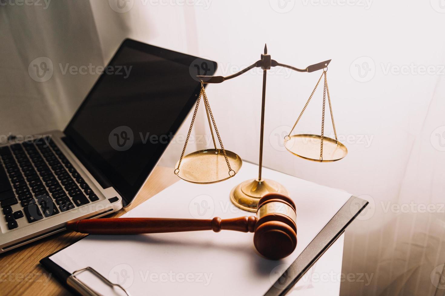 Justice and law concept.Male judge in a courtroom with the gavel, working with, computer and docking keyboard, eyeglasses, on table in morning light photo