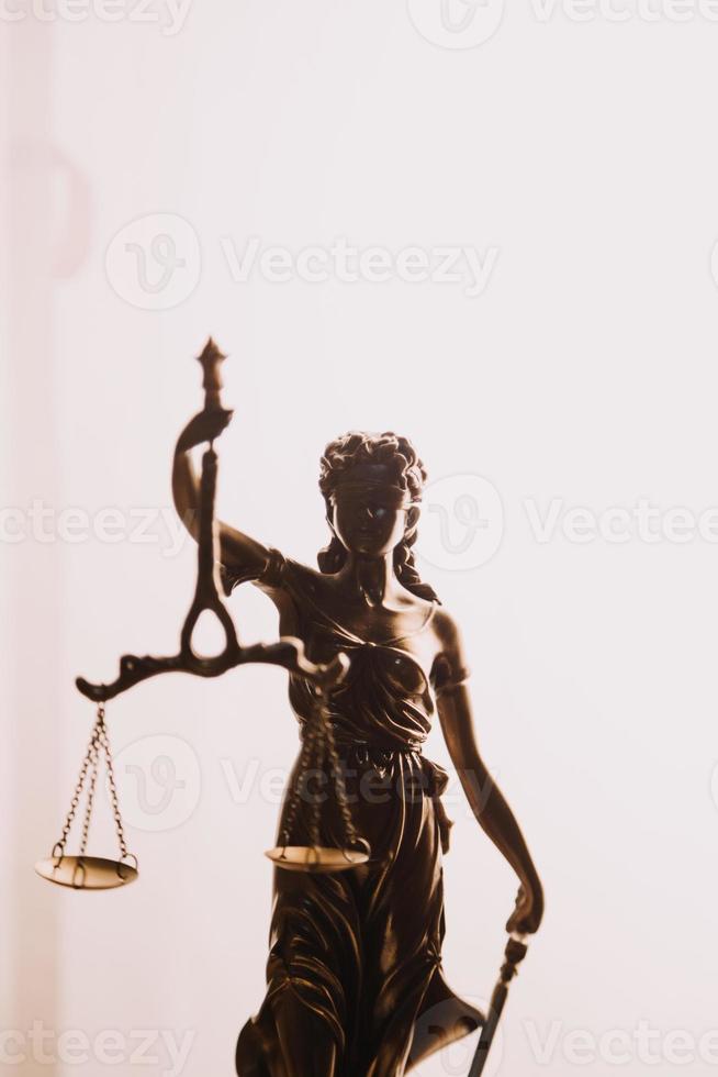 Justice and law concept.Male judge in a courtroom with the gavel, working with, computer and docking keyboard, eyeglasses, on table in morning light photo