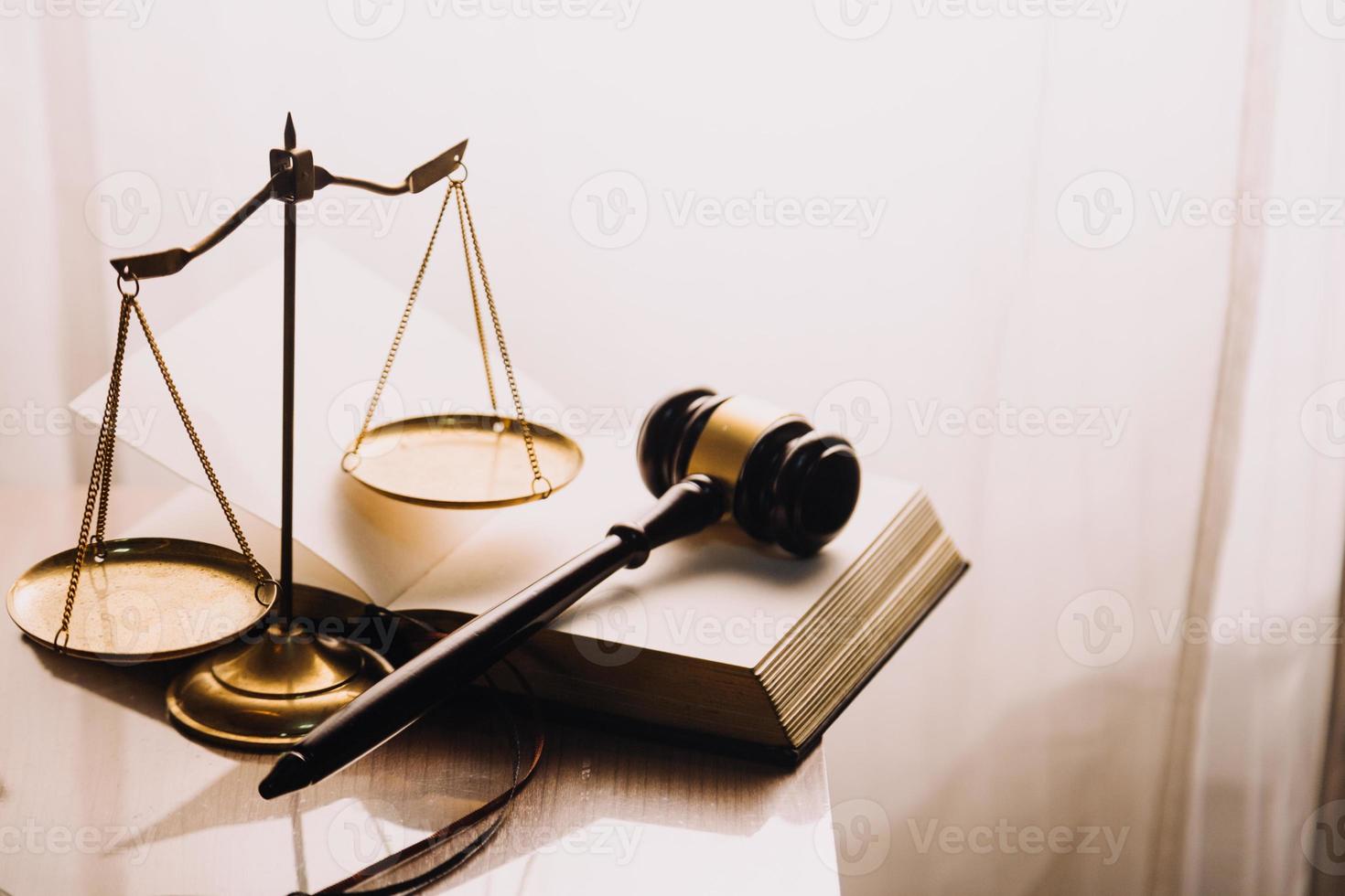 Justice and law concept.Male judge in a courtroom with the gavel, working with, computer and docking keyboard, eyeglasses, on table in morning light photo