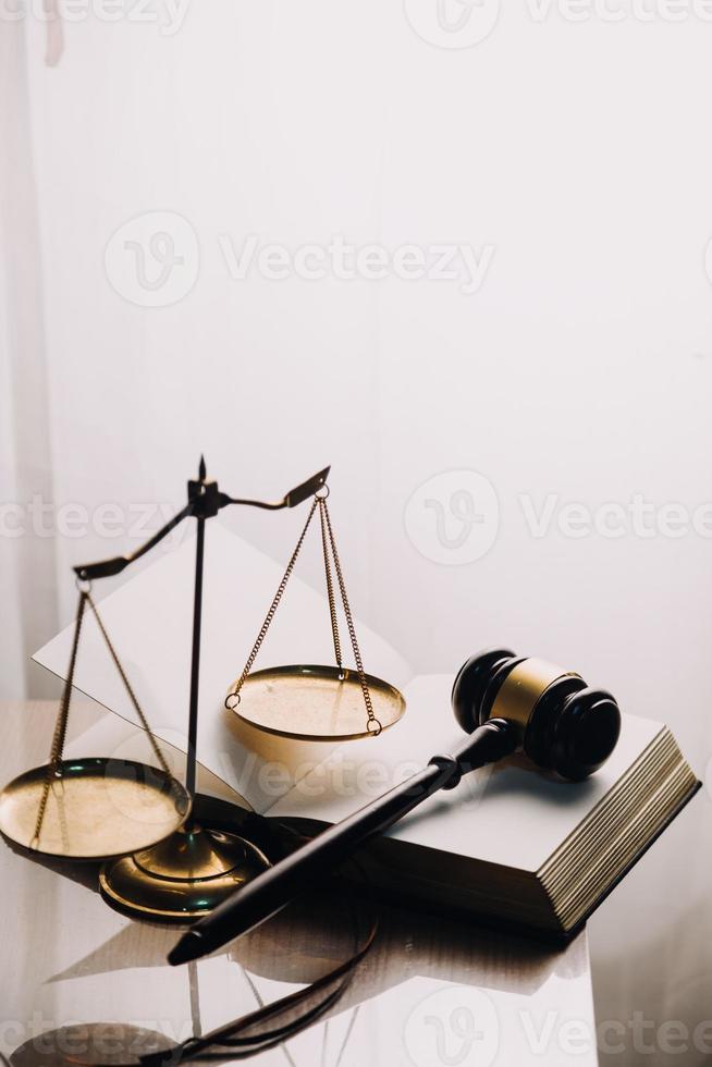 Justice and law concept.Male judge in a courtroom with the gavel, working with, computer and docking keyboard, eyeglasses, on table in morning light photo