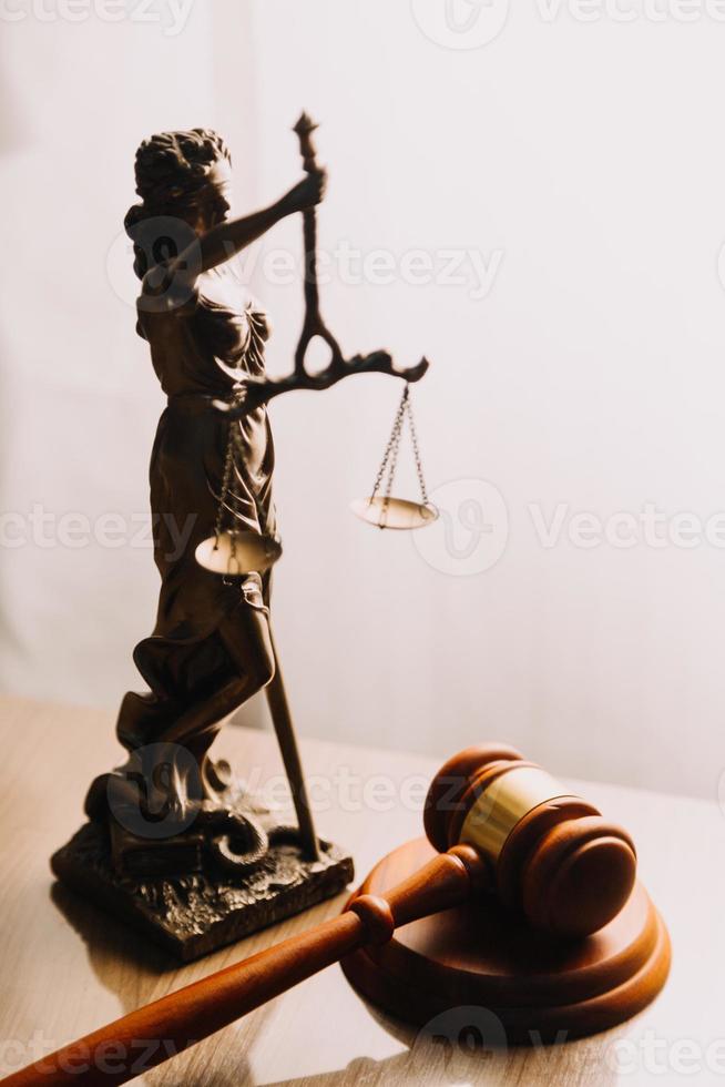 Justice and law concept.Male judge in a courtroom with the gavel, working with, computer and docking keyboard, eyeglasses, on table in morning light photo