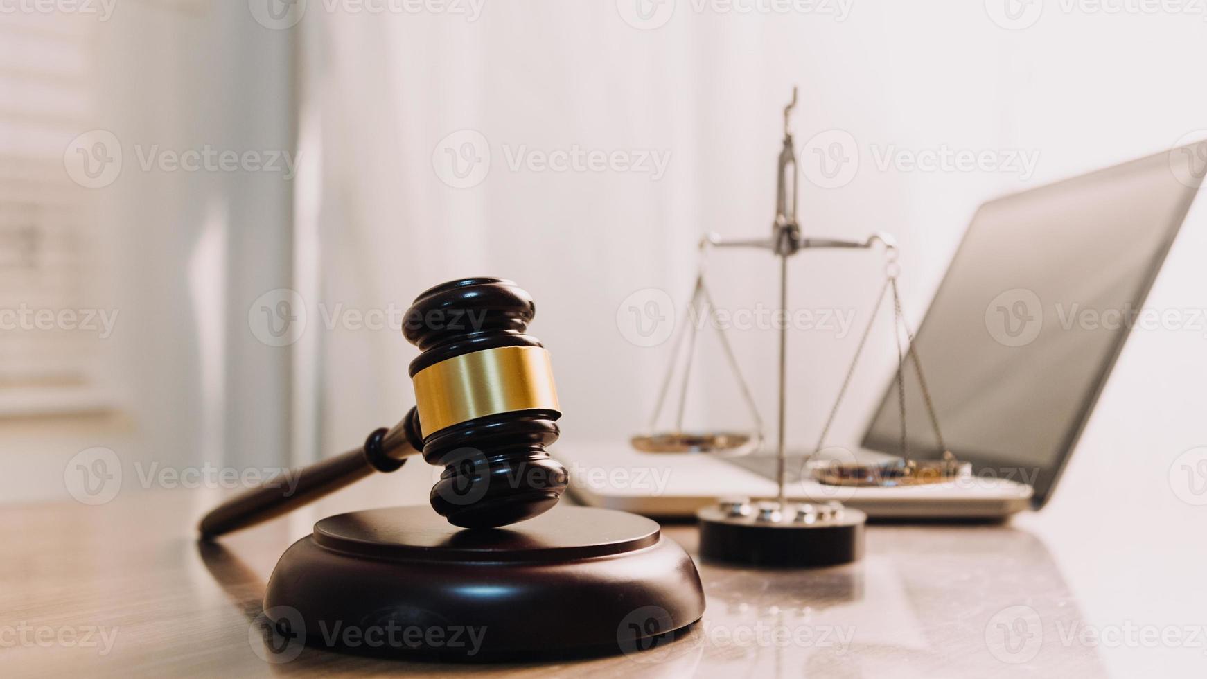 Justice and law concept.Male judge in a courtroom with the gavel, working with, computer and docking keyboard, eyeglasses, on table in morning light photo