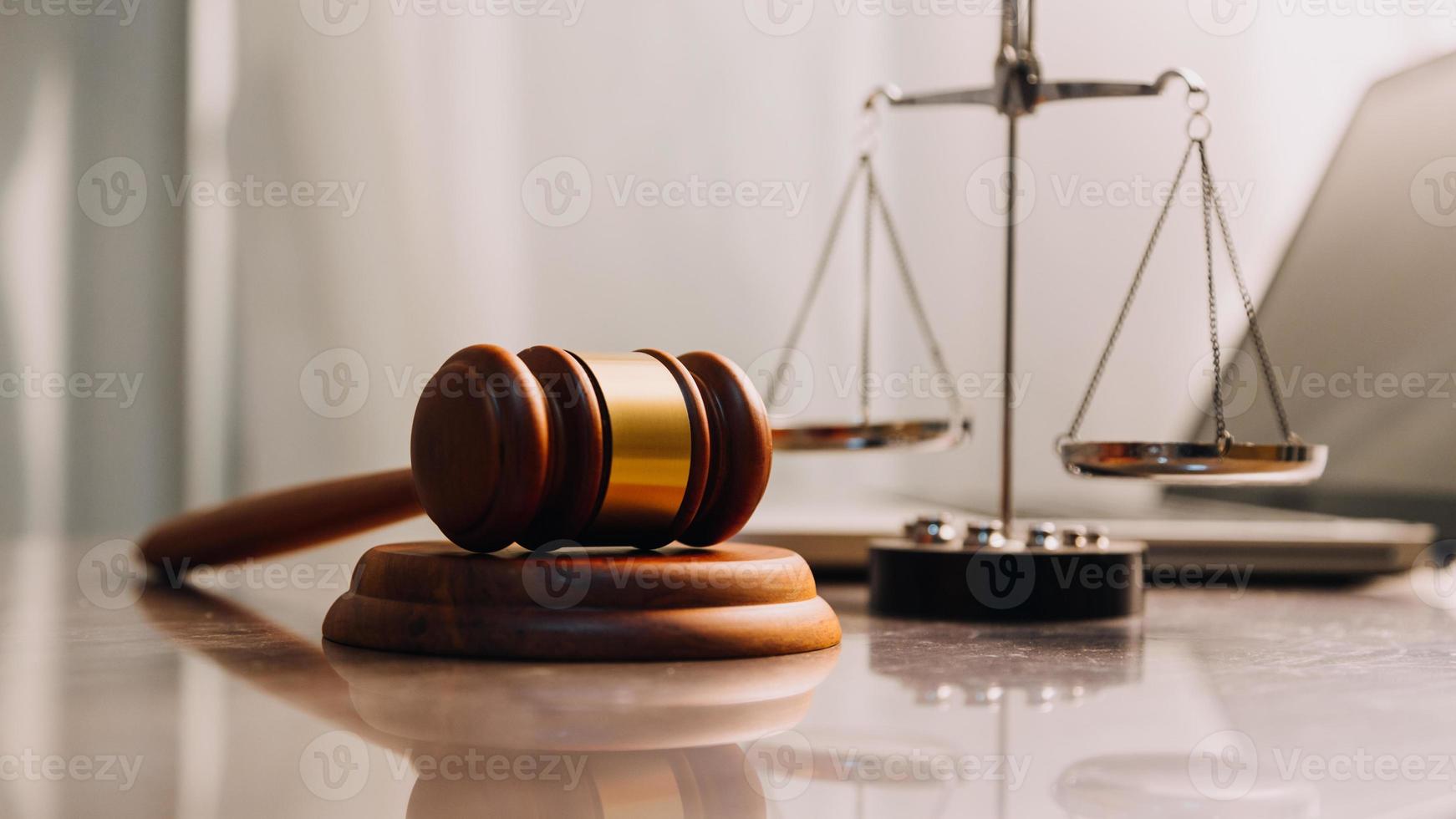 Justice and law concept.Male judge in a courtroom with the gavel, working with, computer and docking keyboard, eyeglasses, on table in morning light photo