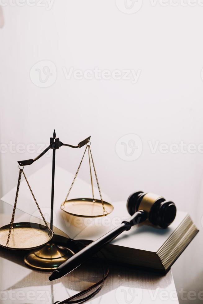 Justice and law concept.Male judge in a courtroom with the gavel, working with, computer and docking keyboard, eyeglasses, on table in morning light photo