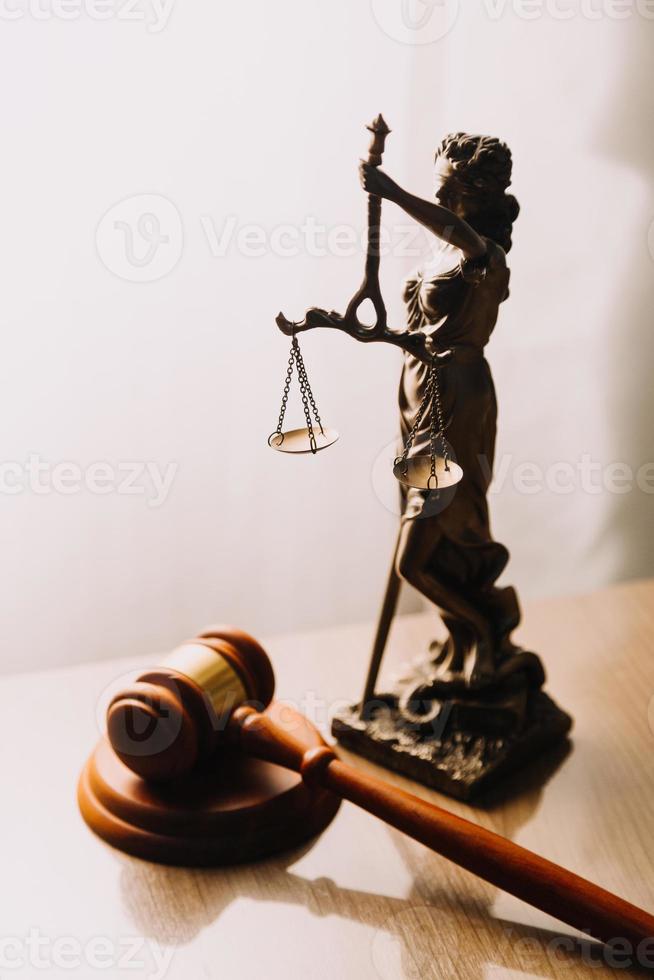 Justice and law concept.Male judge in a courtroom with the gavel, working with, computer and docking keyboard, eyeglasses, on table in morning light photo