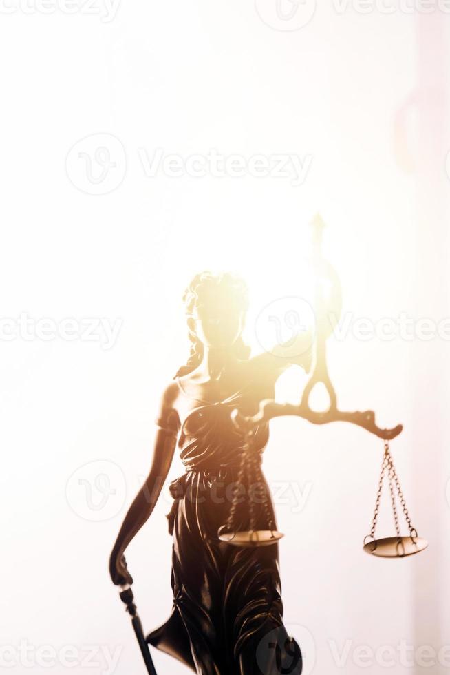 Justice and law concept.Male judge in a courtroom with the gavel, working with, computer and docking keyboard, eyeglasses, on table in morning light photo