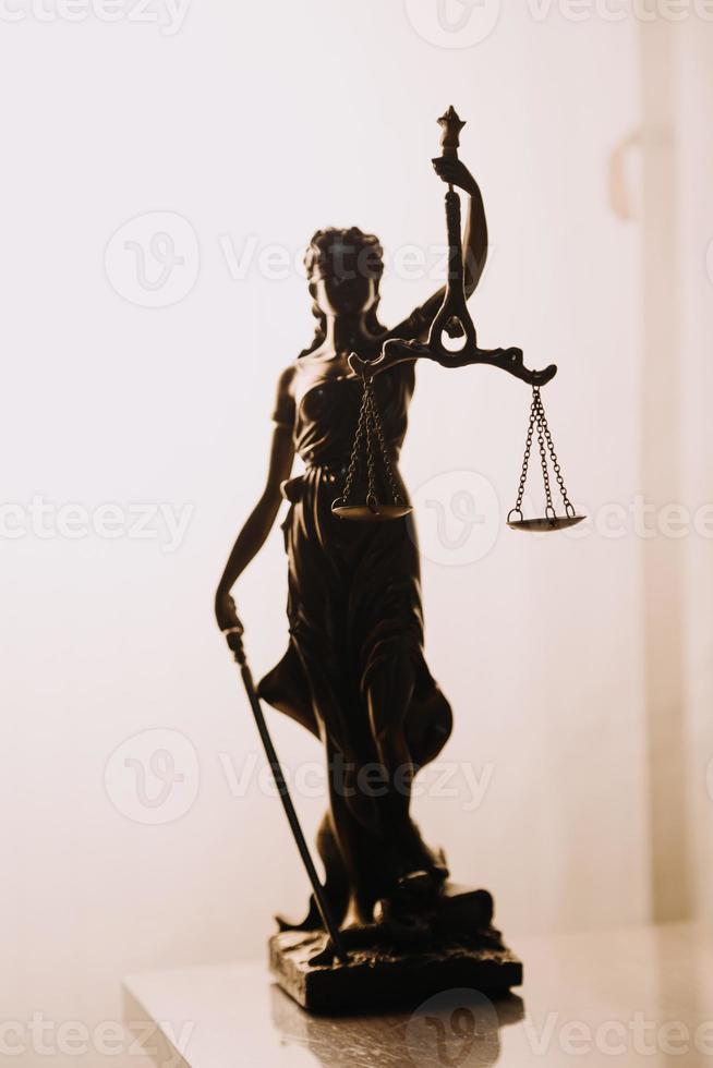 Justice and law concept.Male judge in a courtroom with the gavel, working with, computer and docking keyboard, eyeglasses, on table in morning light photo