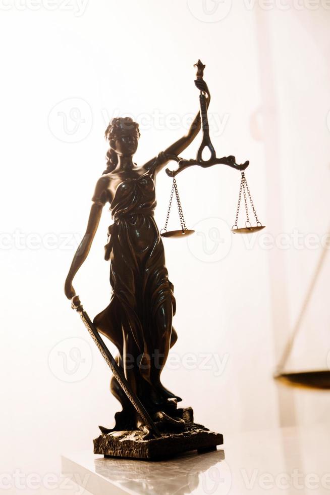 Justice and law concept.Male judge in a courtroom with the gavel, working with, computer and docking keyboard, eyeglasses, on table in morning light photo