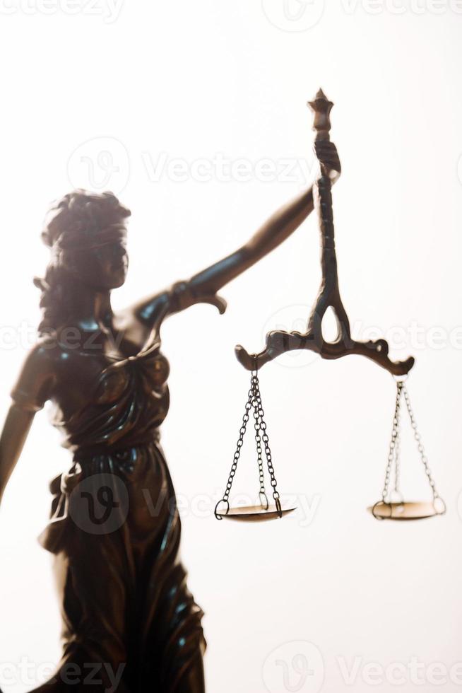 Justice and law concept.Male judge in a courtroom with the gavel, working with, computer and docking keyboard, eyeglasses, on table in morning light photo