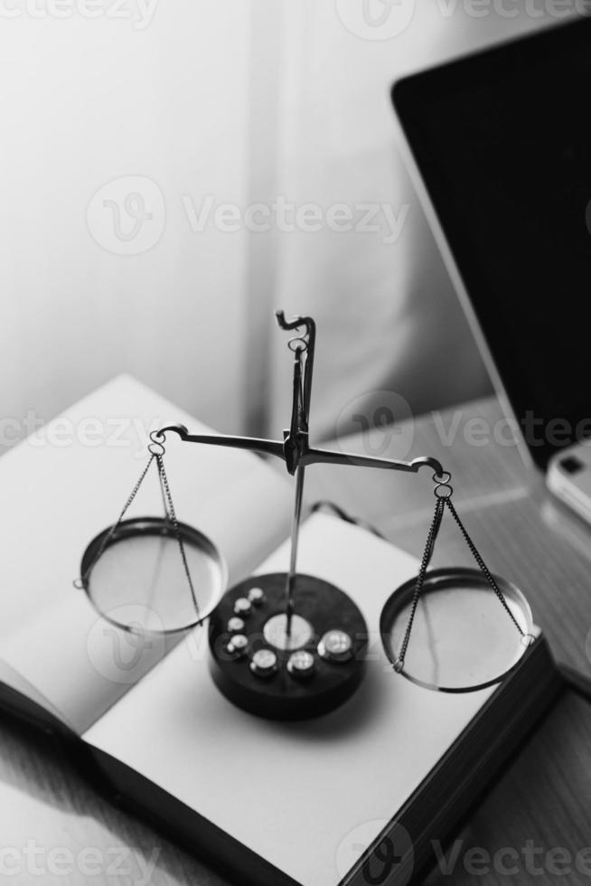Justice and law concept.Male judge in a courtroom with the gavel, working with, computer and docking keyboard, eyeglasses, on table in morning light photo