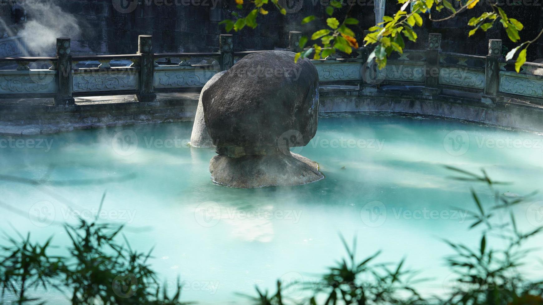 The hot spring view with the steam rising up from the hot water surface photo