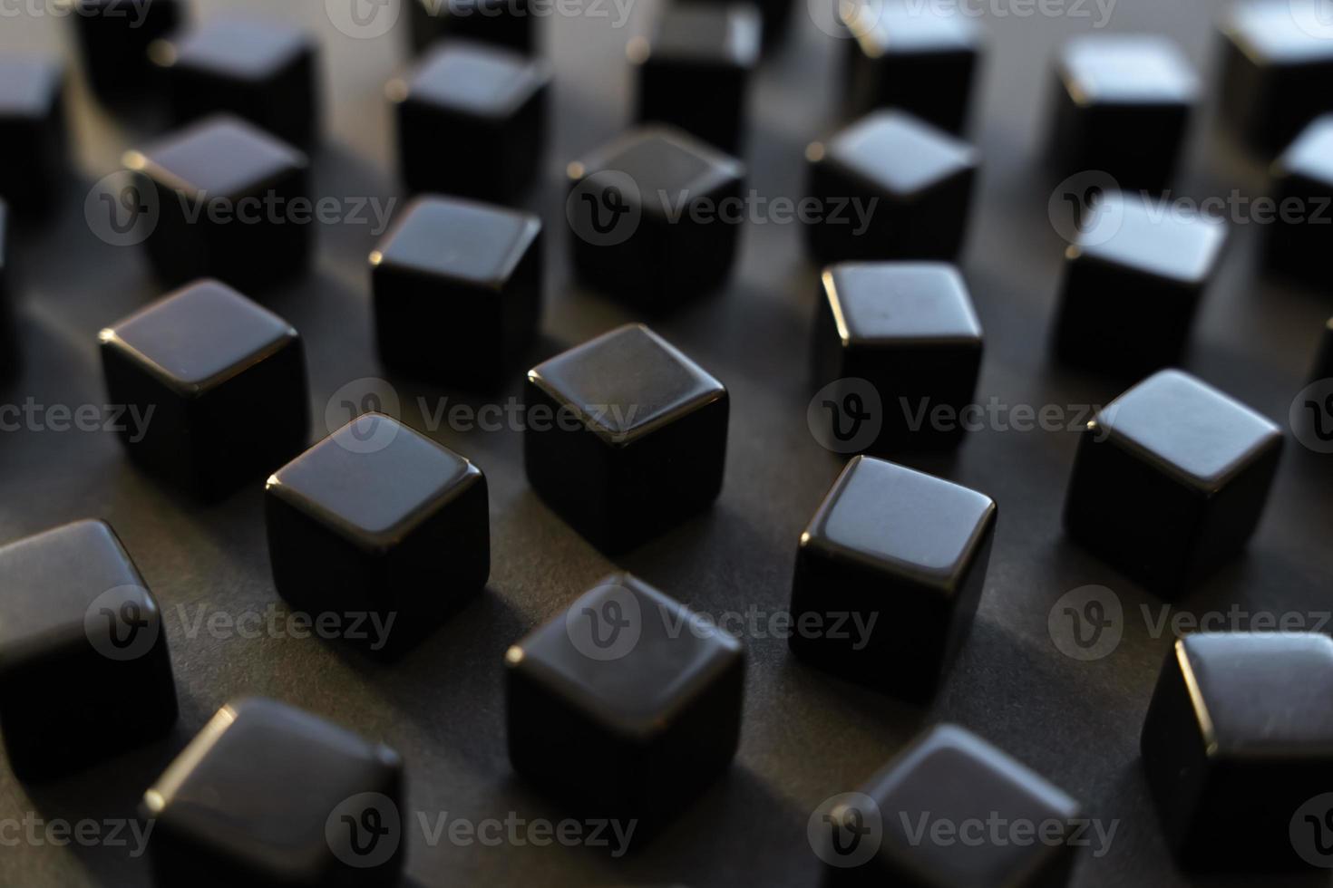 Black blocks on a dark background. Scattered cubes. Abstraction, field blur. Simplicity and elegance. Solidity, shine. photo