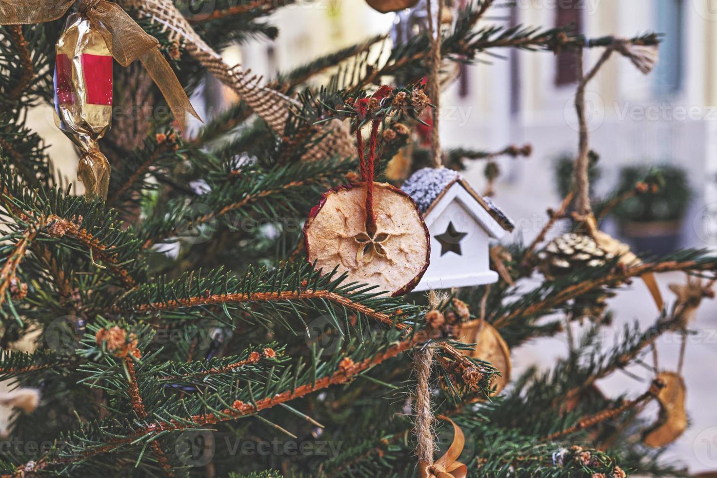 decorar árbol de navidad con manzana seca, casa de juguete. adornos navideños naturales para el árbol de navidad foto