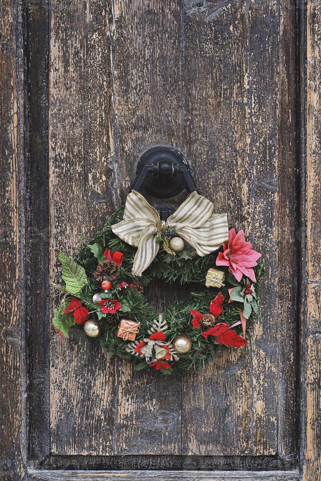 Christmas crown wreath upon an old wooden door. Traditional home decor during Christmas photo