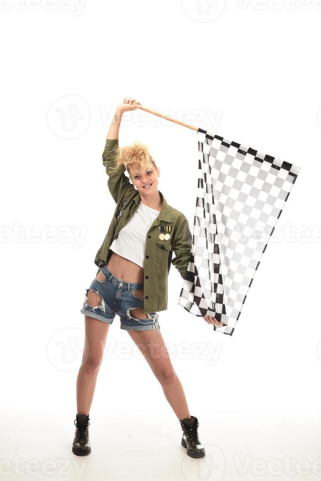 hermosa modelo sosteniendo la bandera de acabado aislada sobre fondo blanco. bandera de acabado de automovilismo en manos de una modelo femenina. foto