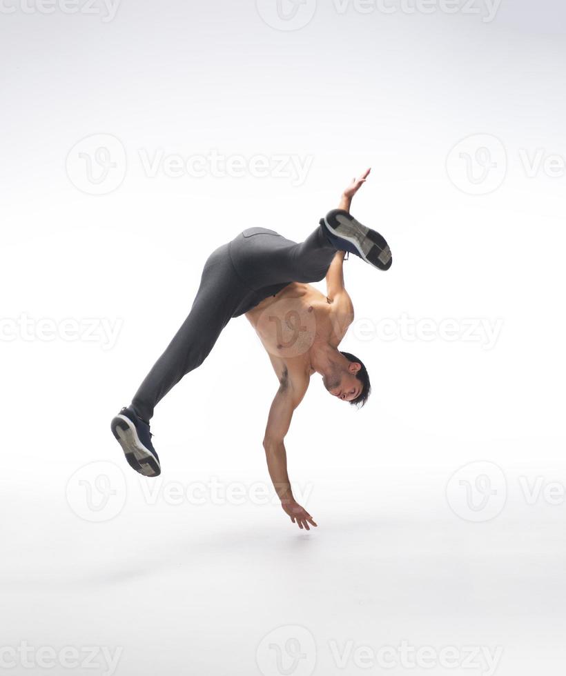 Cool young break dancer performing in studio on white background. photo