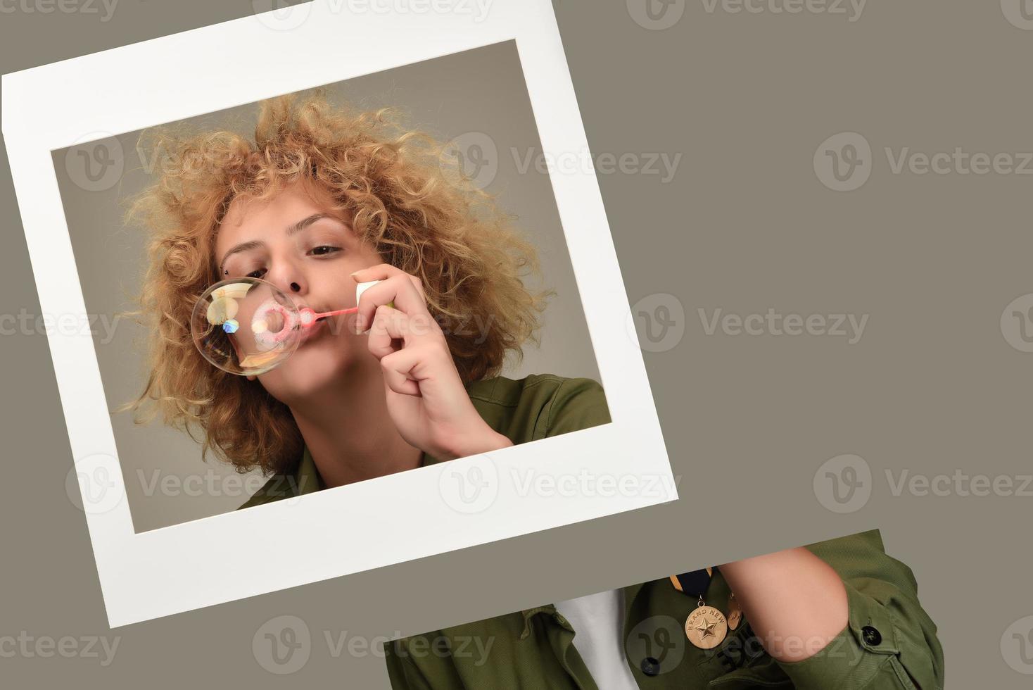 Attractive young female model blowing soap bubbles photo