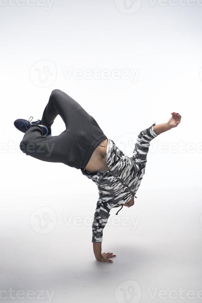 Cool young break dancer performing in studio on white background. photo