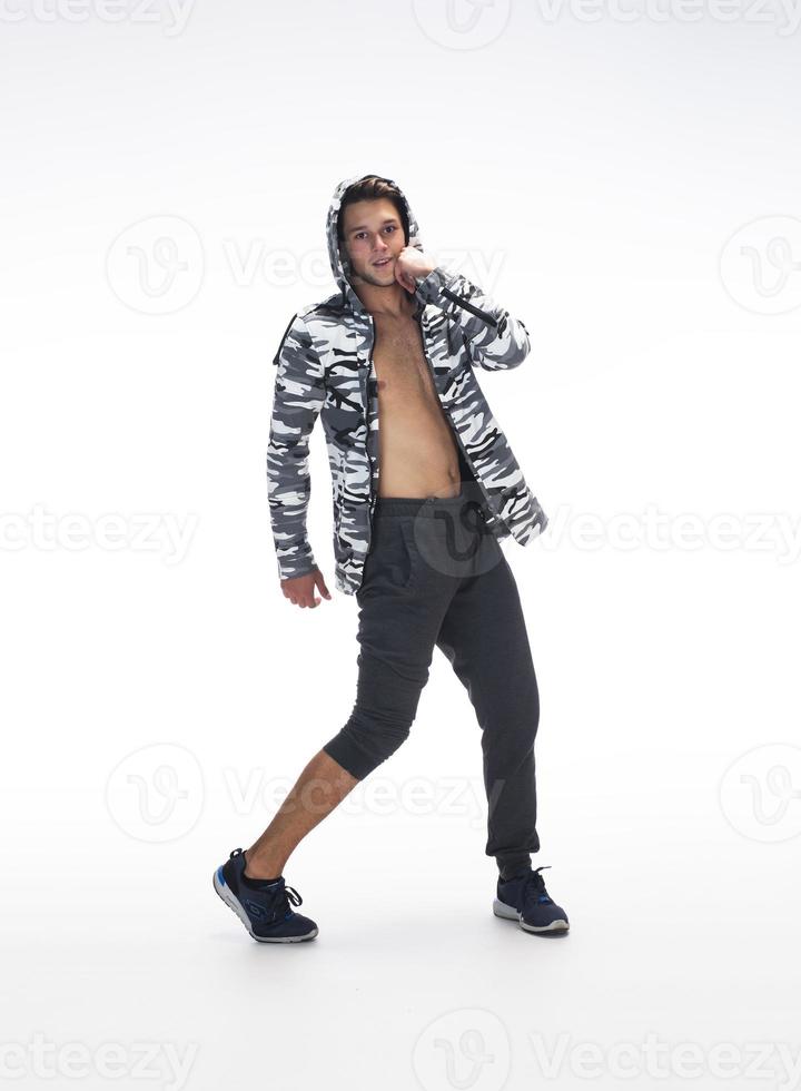 Cool young break dancer performing in studio on white background. photo