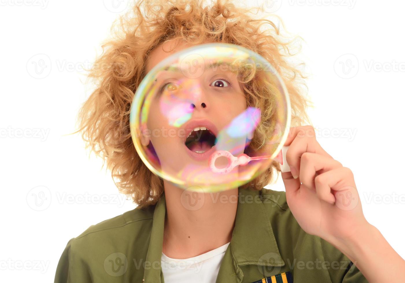 Attractive young female model blowing soap bubbles photo