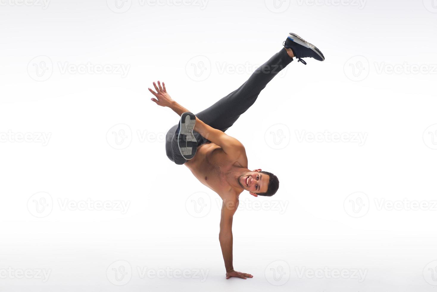 Cool young break dancer performing in studio on white background. photo