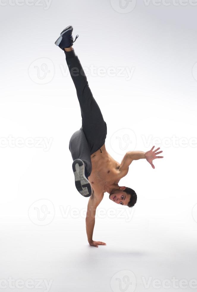 Cool young break dancer performing in studio on white background. photo