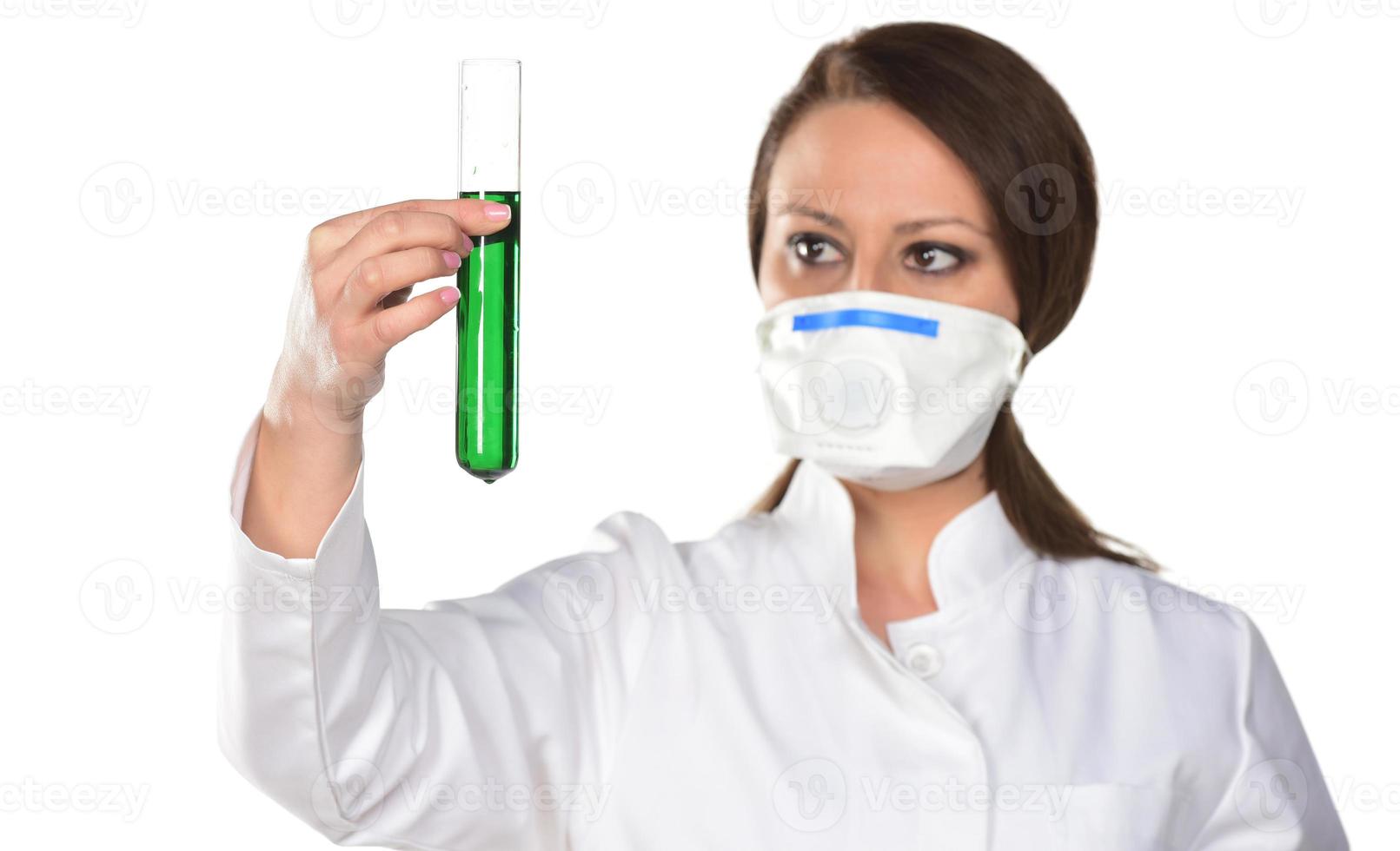 Scientist with white mask holding tube with green liquid. Isolated on white background. photo