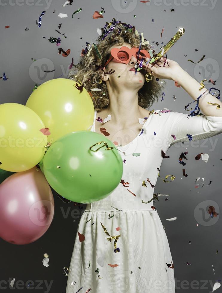 Beautiful woman celebrating New Year with confetti and holding sign. photo