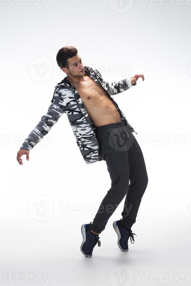 Cool young break dancer performing in studio on white background. photo