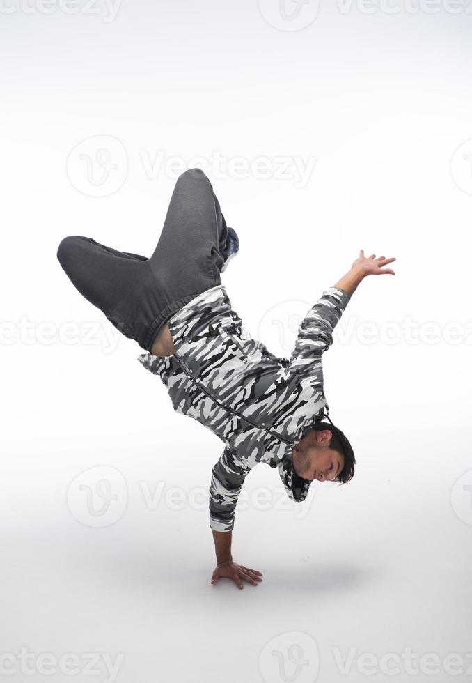 Cool young break dancer performing in studio on white background. photo