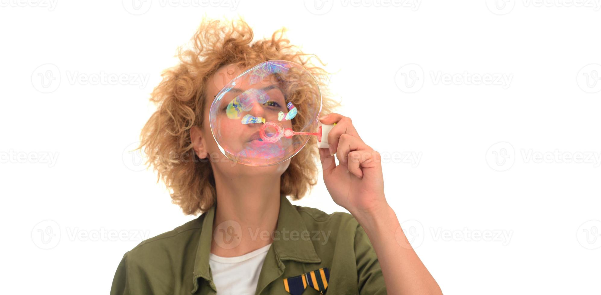 Attractive young female model blowing soap bubbles photo