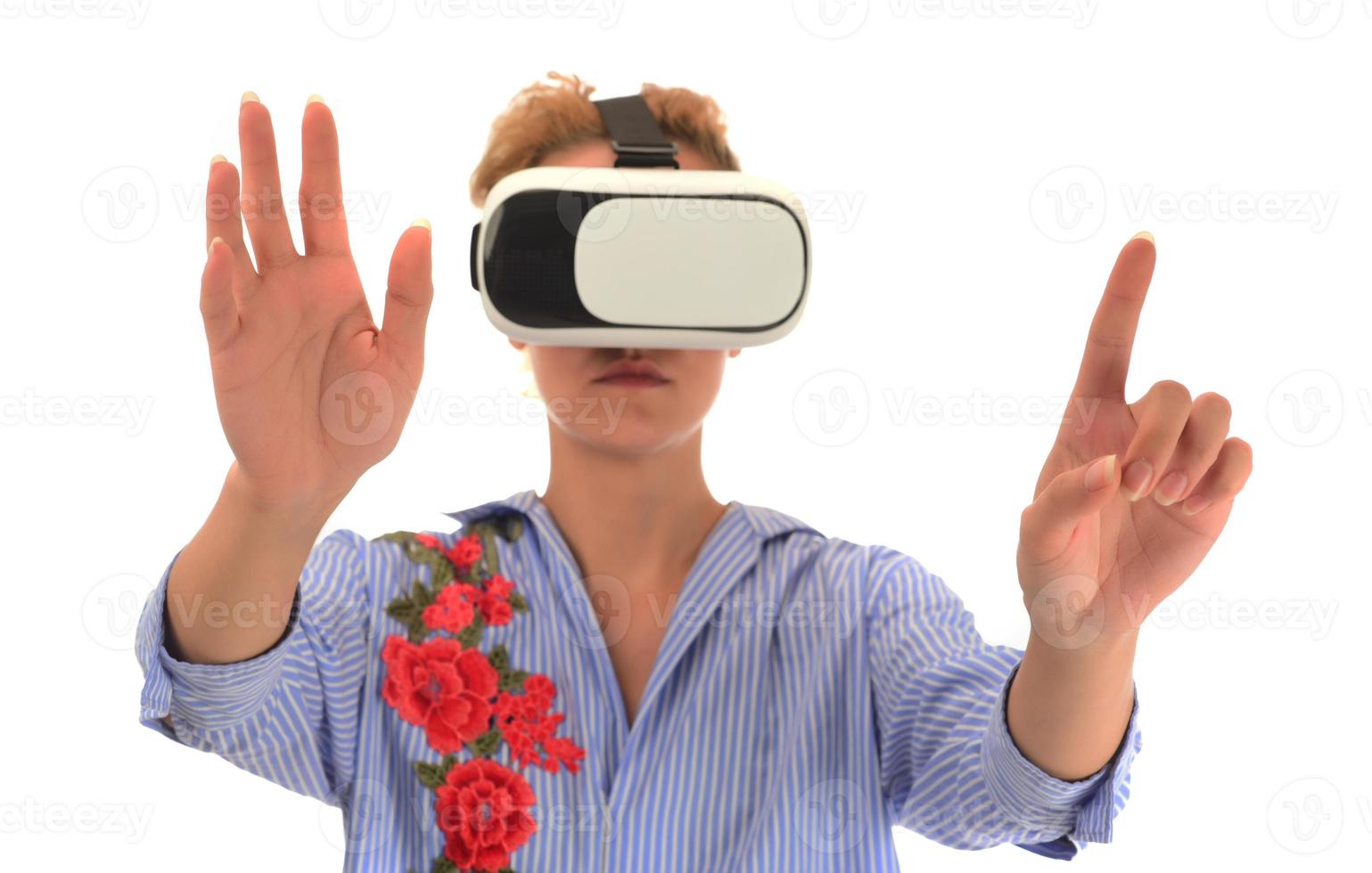 Pretty beautiful excited woman in VR headset looking up and trying to touch objects in virtual reality photo