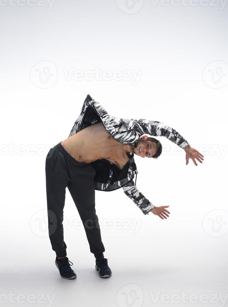 Cool young break dancer performing in studio on white background. photo